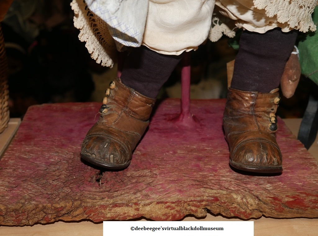 Antique leather boots worn by a doll