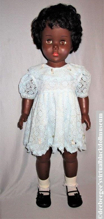 Coloured Nurse Walking Doll by Reliable Toys, 1961, redressed in an infant-size dress, socks, and shoes