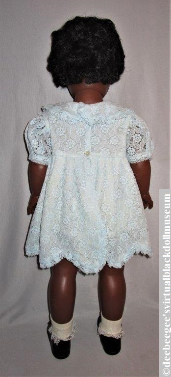 Coloured Nurse Walking Doll by Reliable Toys, 1961, redressed in an infant-size dress, socks, and shoes